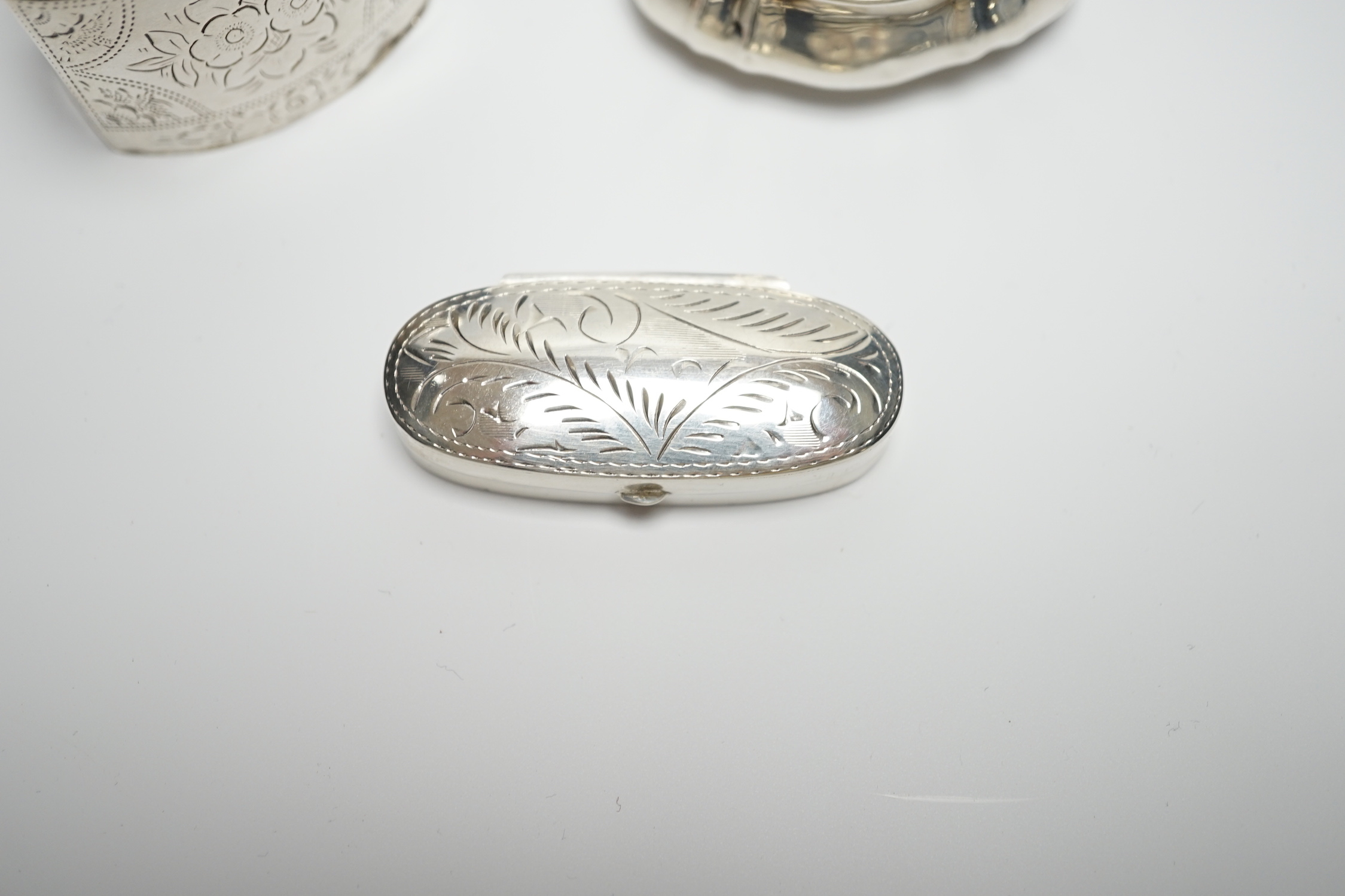 A late Victorian silver pill box with Reynold's Angel decorated cover, 47mm, a modern silver pill box and a Dutch white metal box.